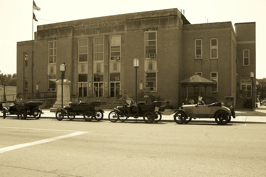 Our History - Vintage Photo of Downtown McArthur Ohio with Row of Antique Cars Parked Next to a Commercial Building